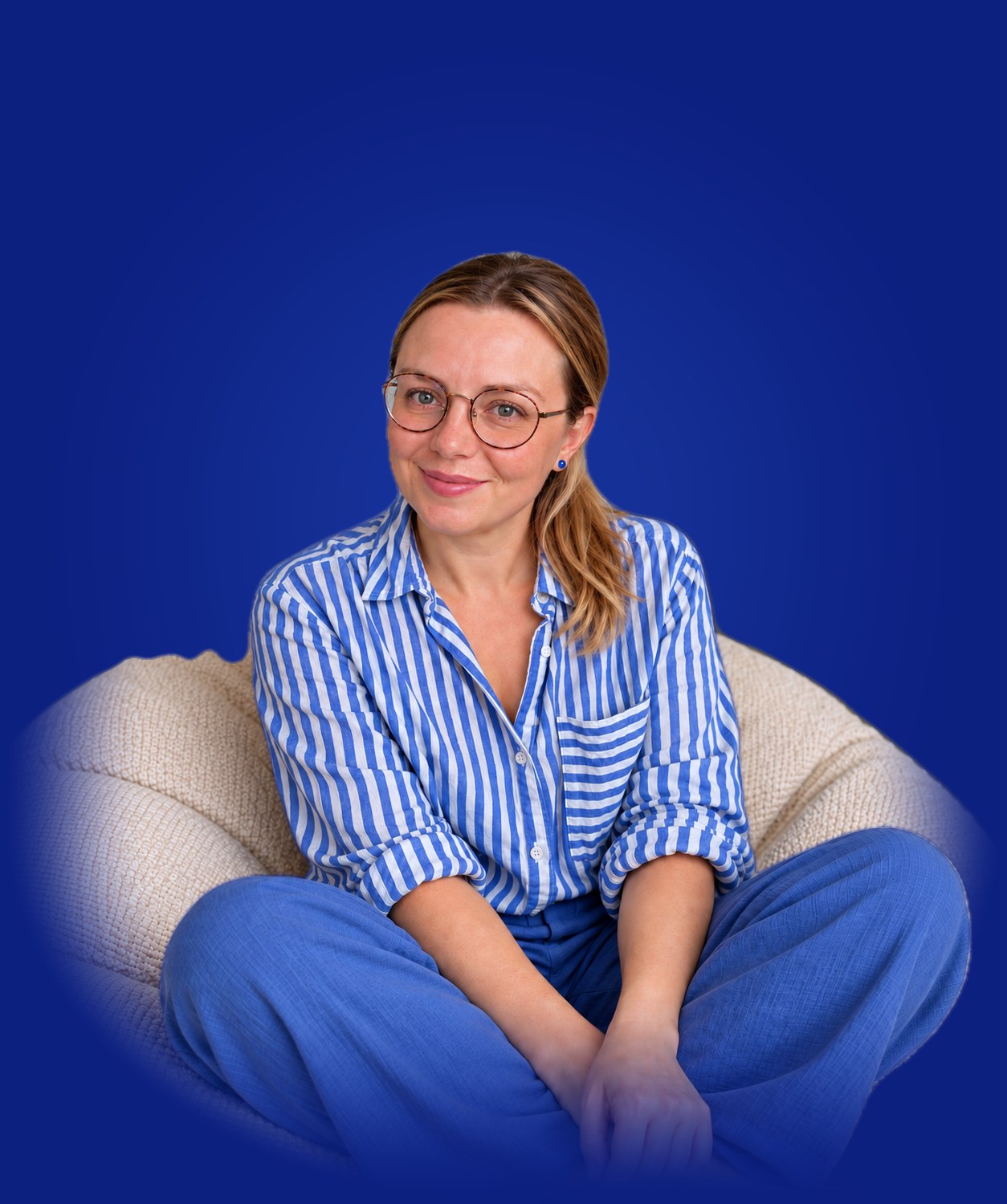 Lenka Stawarczyk sitting on a beanbag, with a microphone, flipchart, notebook, marker, sticky notes and a mug floating around her